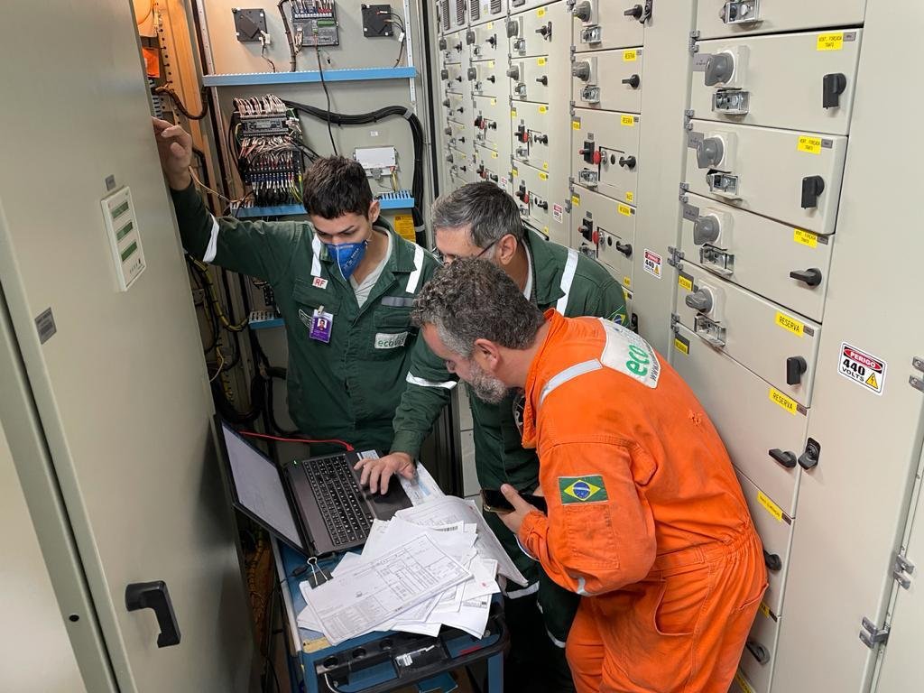 Equipe Ecovis em campo analisando painel elétrico industrial
